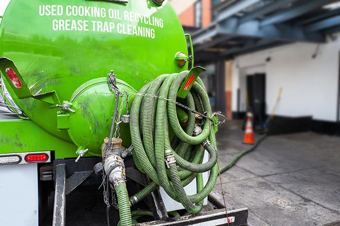 a technician pumping a grease trap in a commercial building in Oracle